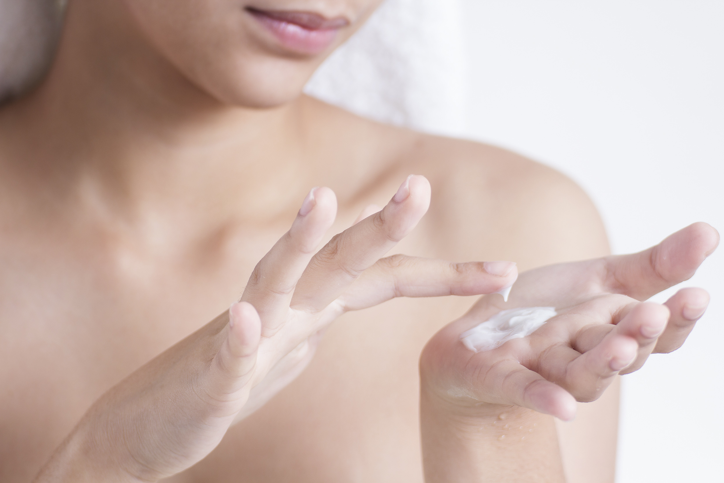 Woman moisturizing her skin